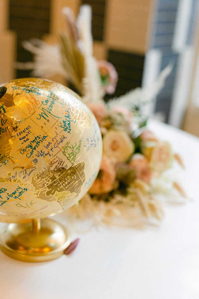 The guests sign a globe at the reception, captured by New York City wedding photographer, Molli Photo.