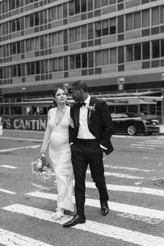 The bride and groom walk to the wedding ceremony, crossing the street in New York City, taken by Molli Photo, New York City wedding photographer.