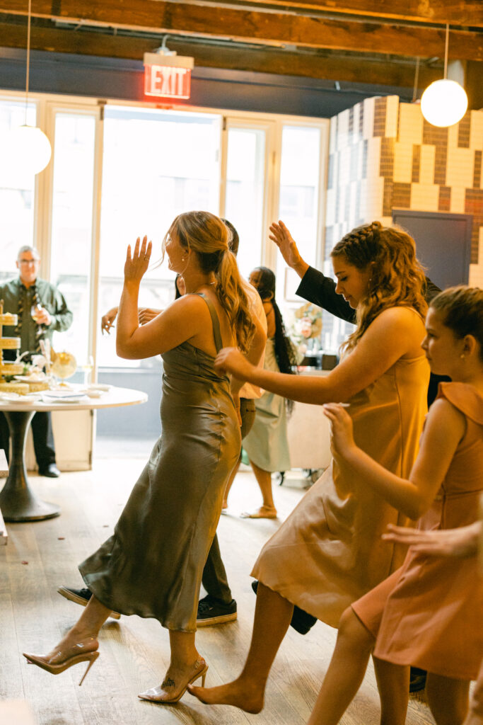 Wedding reception guests dance and laugh after the ceremony, captured by New York City wedding photographer, Molli Photo.