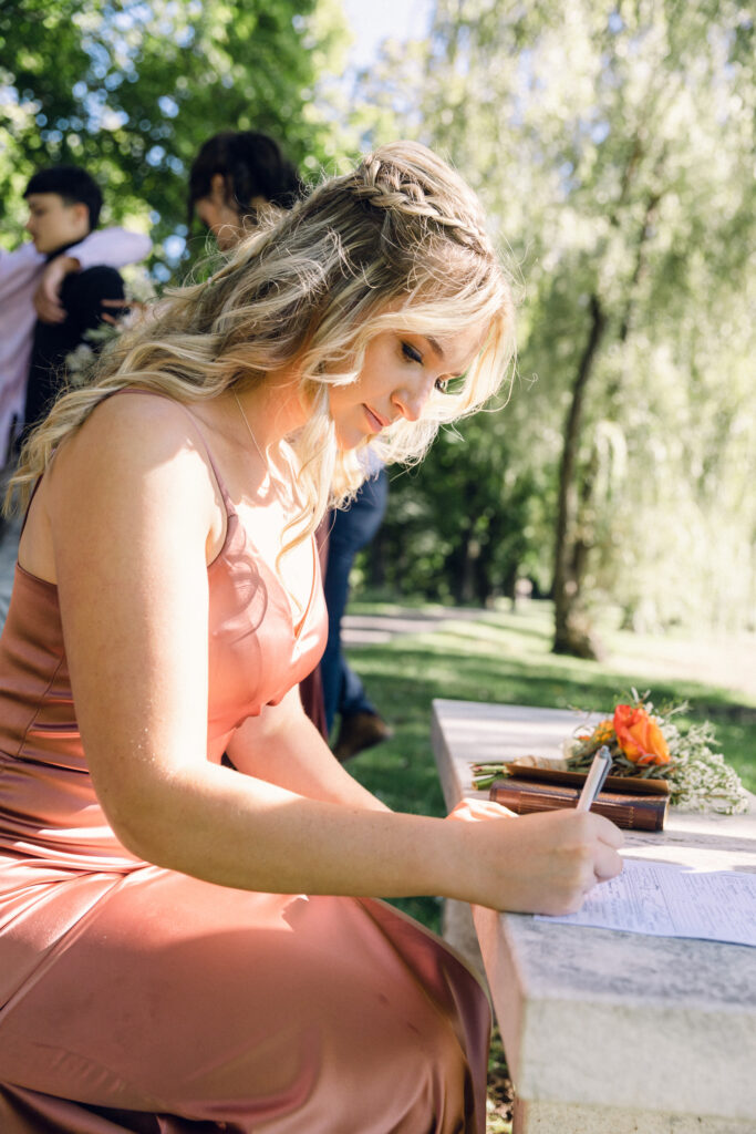 The maid of honor signs the marriage license as a witness of the wedding ceremony.