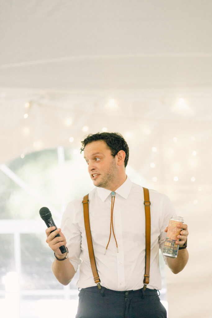 The best man gives a speech during the toasts.