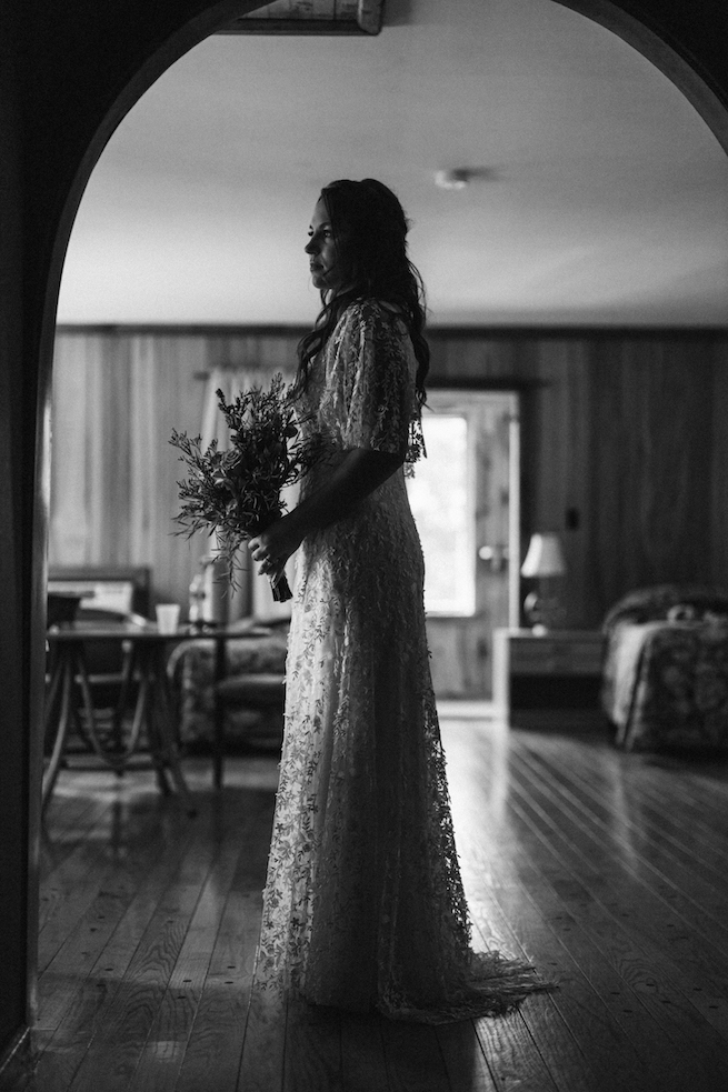 The bride standing in the doorway at Glen Brook Farm's cabin.