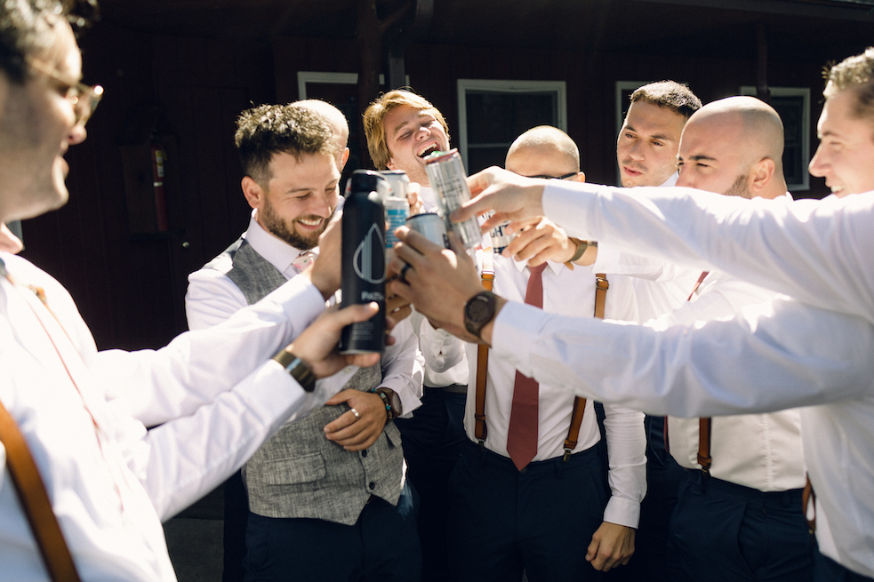 The groomsmen laugh as they toast the groom.