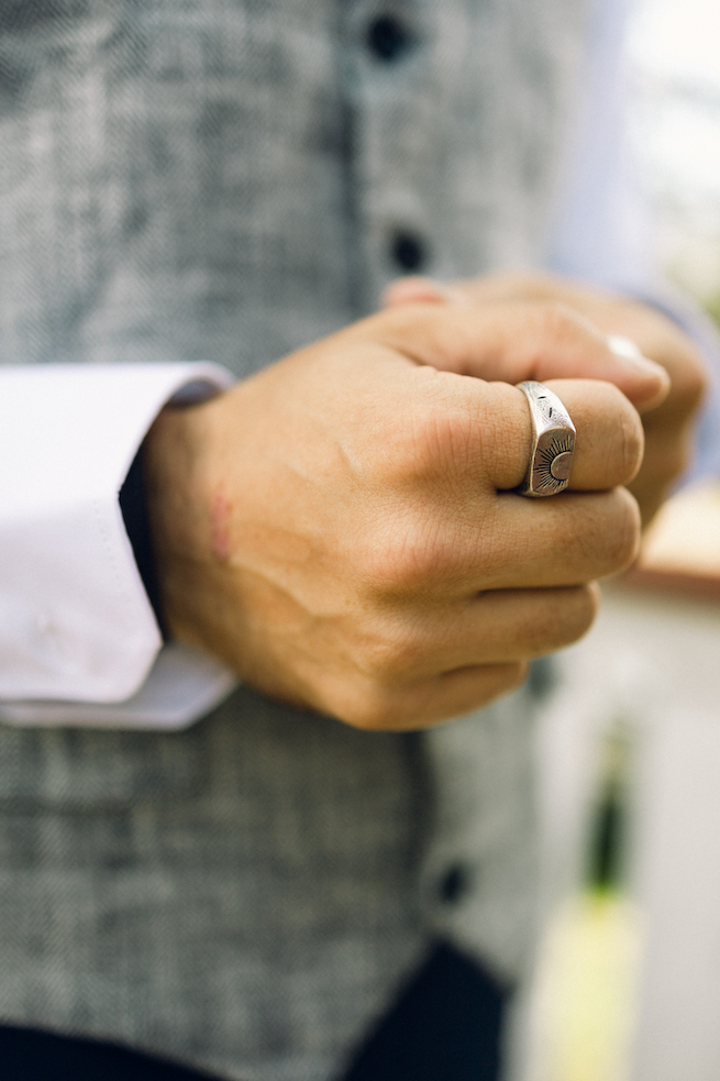 The groom's showing off his custom engraved, silver wedding band.
