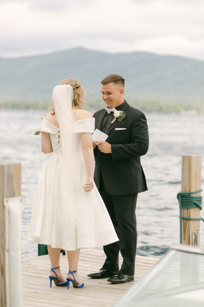 The bride and groom read each other handwritten notes after their first look in front of Lake George.