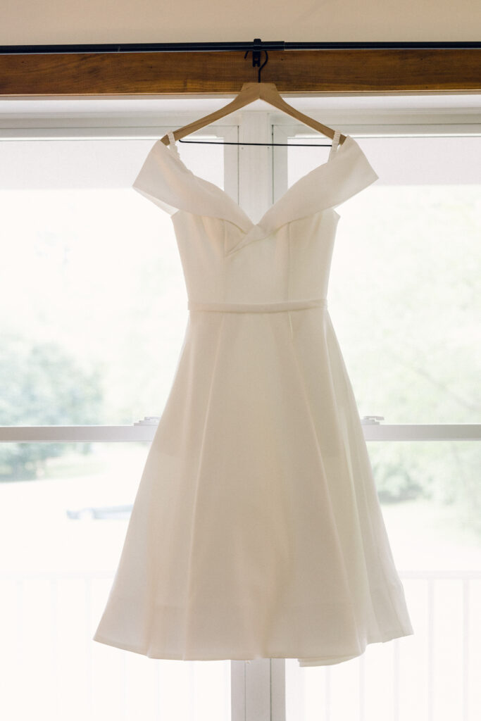 The bride's dress hanging in the window at a Lake George wedding.
