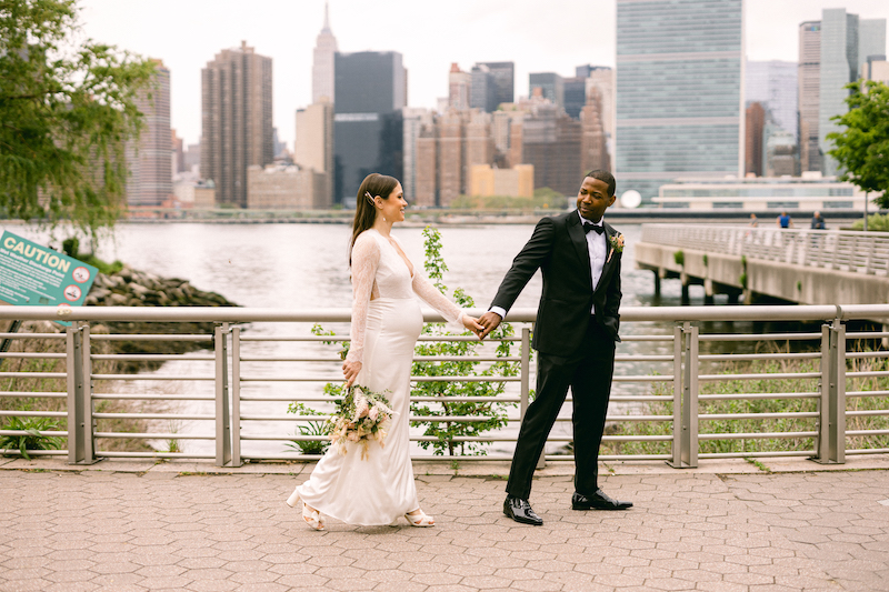 The groom leads the bride by hand as they walk to the wedding ceremony, crossing the street in New York City, taken by Molli Photo, New York City wedding photographer.