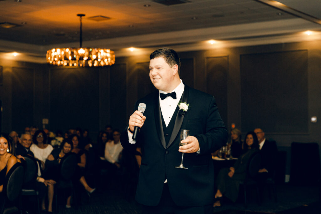 A groomsmen delivering a wedding reception toast at a Queensbury Hotel wedding.