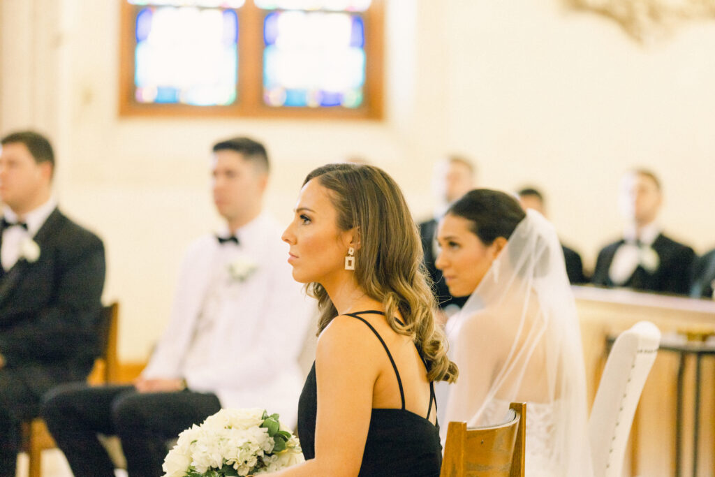 The bride and groom sit below the altar at a traditional catholic ceremony at St. Mary's Catholic Church in Upstate New York.