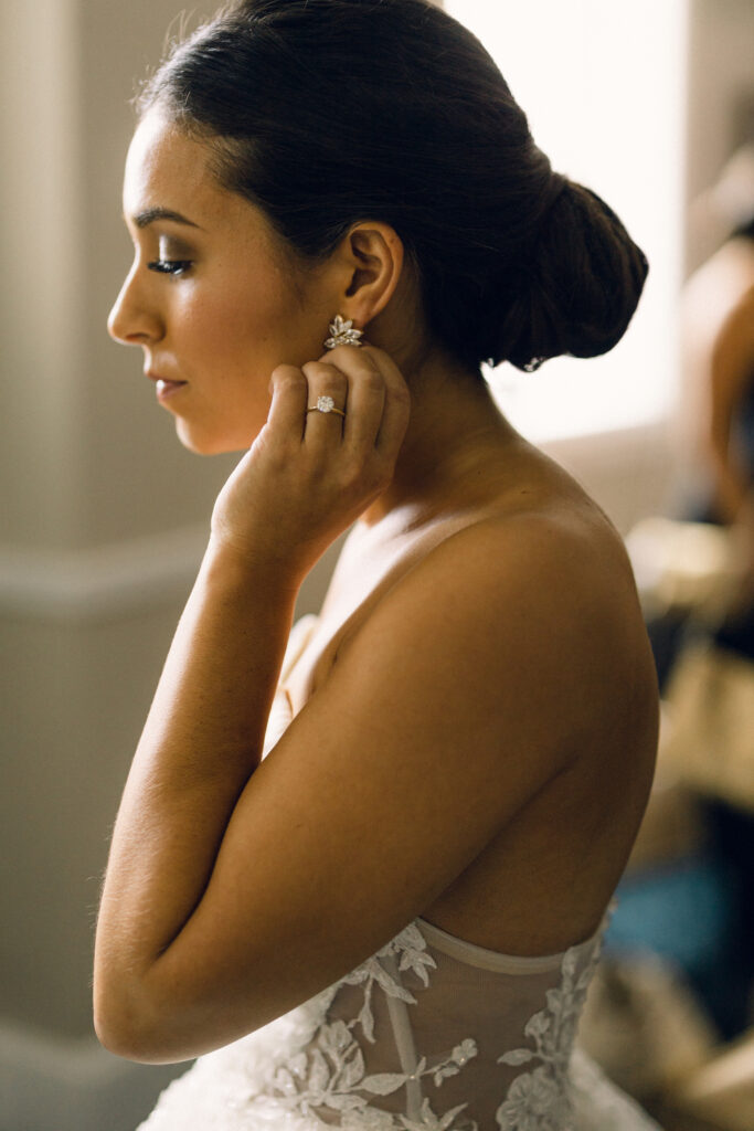 The bride putting on her jewelry before a New York wedding in Lake George. 
