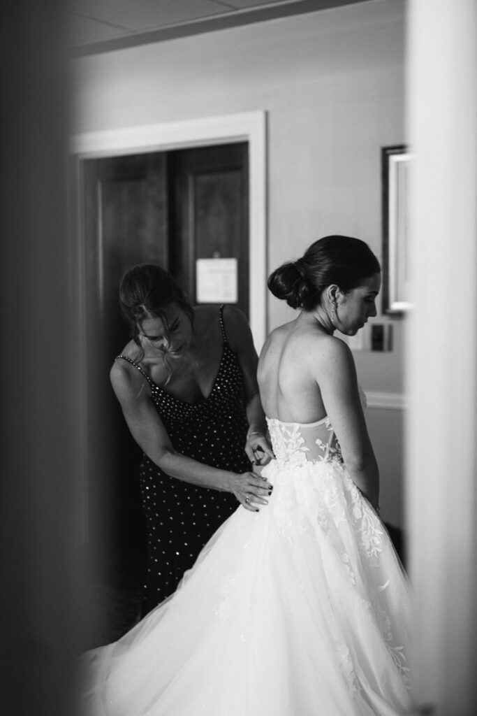 The mother of the bride helping the bride get ready for the wedding ceremony.