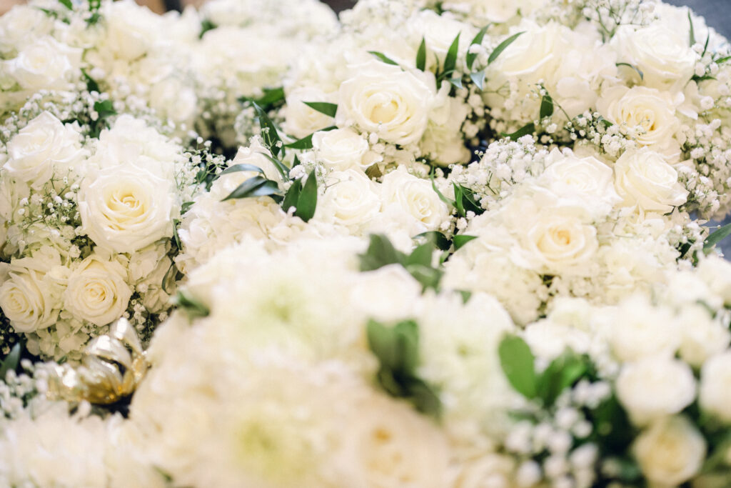 Wedding florals pictured of white roses, white hydrangea, and white babies breath.