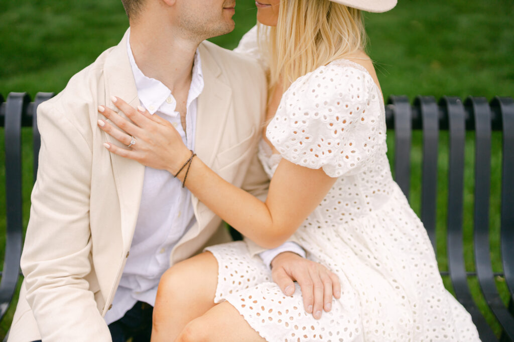 A couple sitting on a bench for an outdoor New York engagement session.