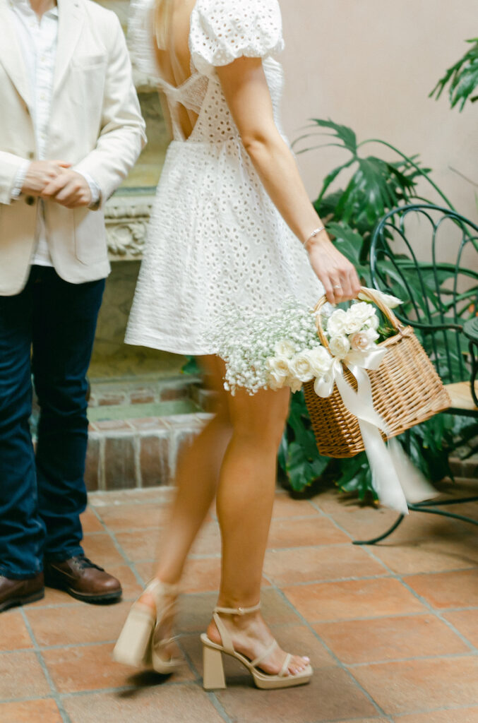 Detail engagement photography shot of a wicker basket of white florals.