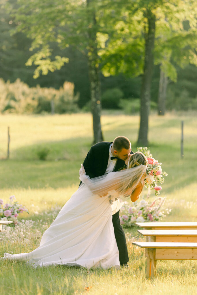 Bride and groom kiss at the altar in a meadow at Mountain Air Strip Farm in Saratoga County, New York.