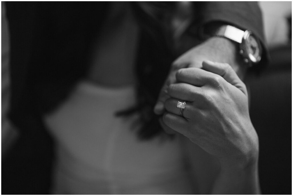 Details of a bride's ring while holding hands with her groom