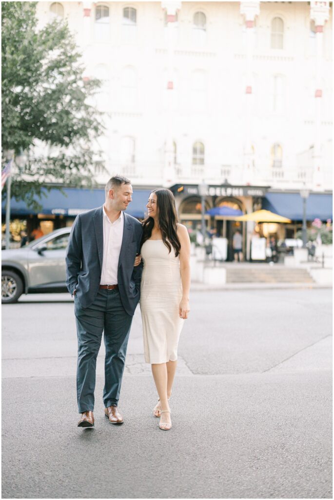 A bride and groom walk int he street across from the the adelphi hotel wedding venue