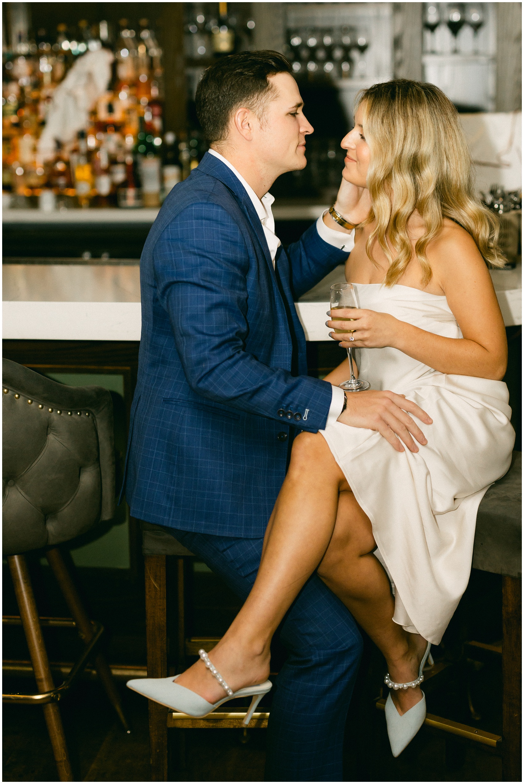 Newlyweds share an intimate moment at the bar with champagne