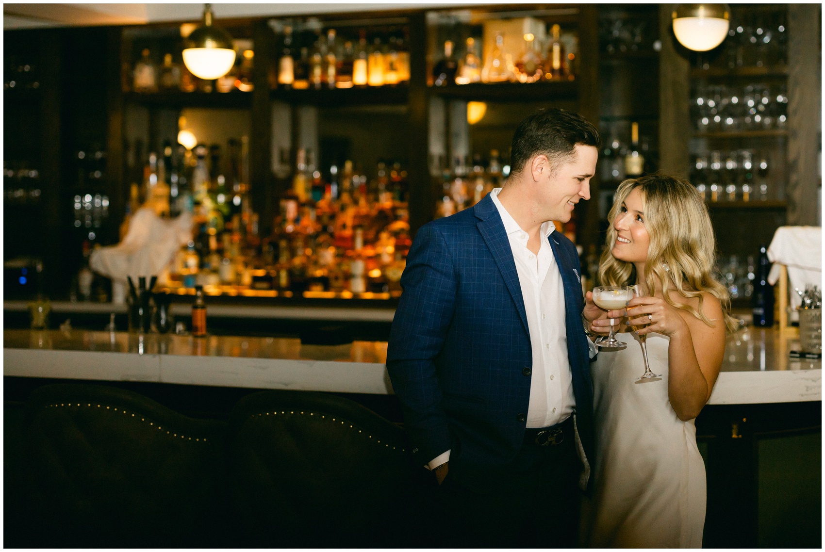 Newlyweds enjoy a drink at the empty bar at their wedding