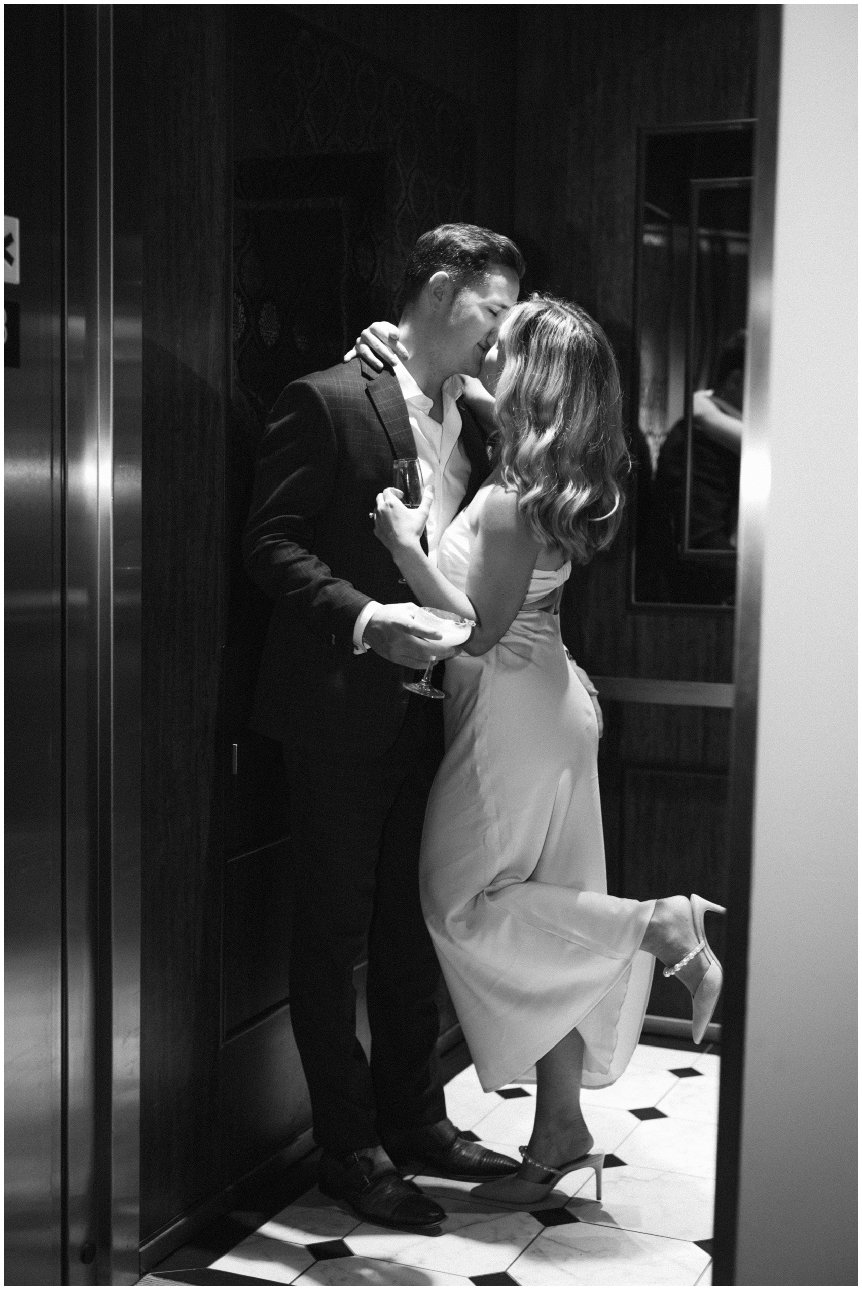 Newlyweds kiss in an elevator with a leg popped at the adelphi hotel wedding